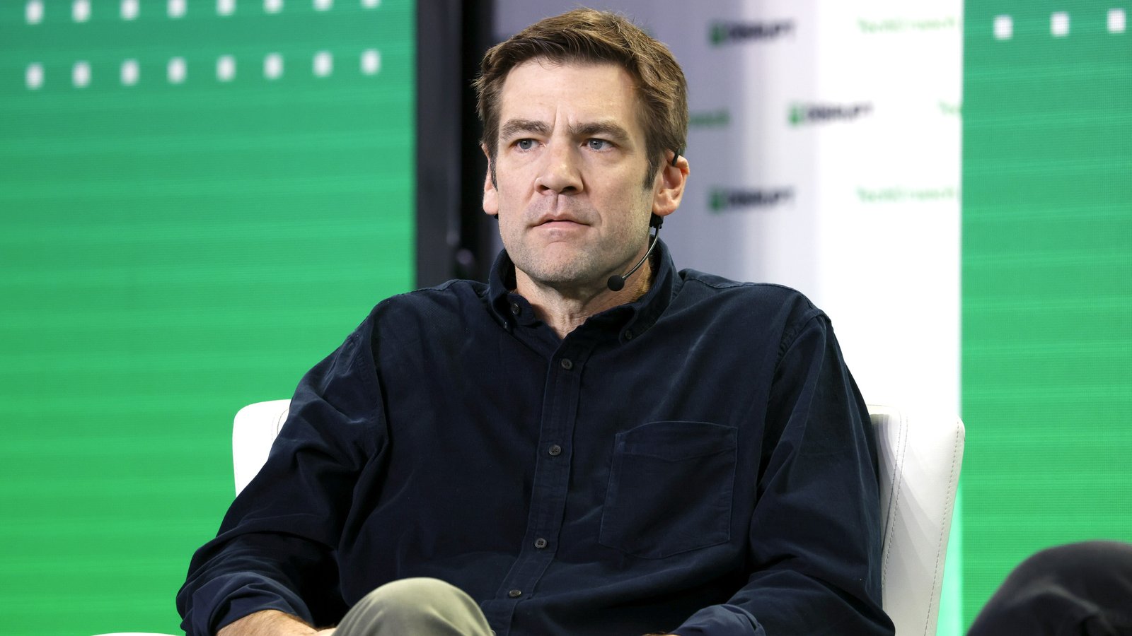 Chris Dixon seated on stage at the TechCrunch Disrupt conference in front of a green backdrop