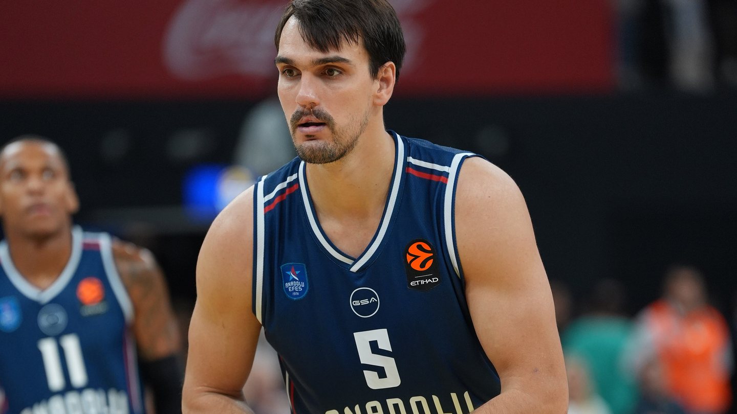 Anadolu Efes forward Dario Šarić, wearing number 5 in a navy kit, holds the ball during a EuroLeague game