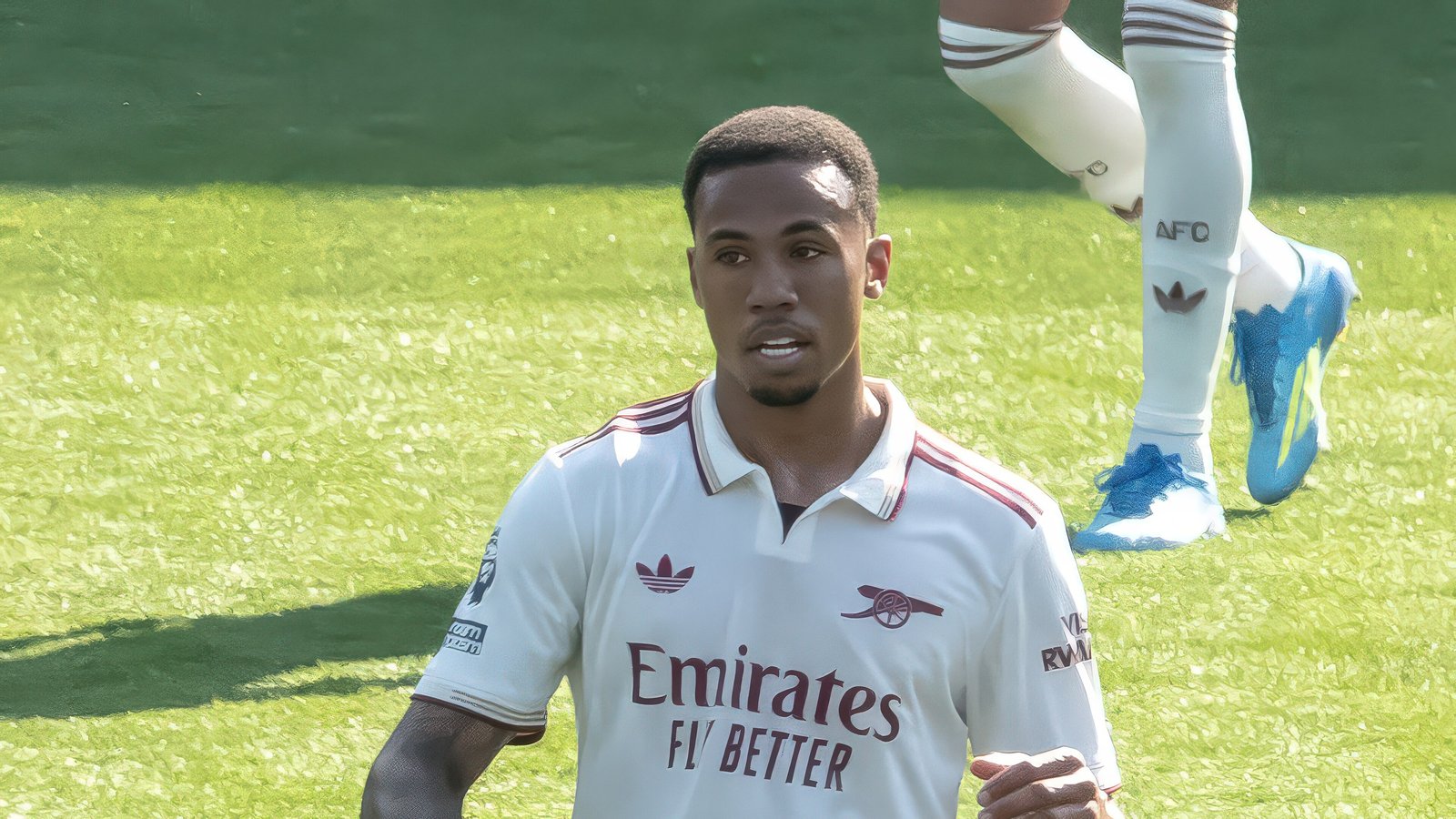 Arsenal defender Gabriel Magalhães in a white away kit running on the pitch during a Premier League match