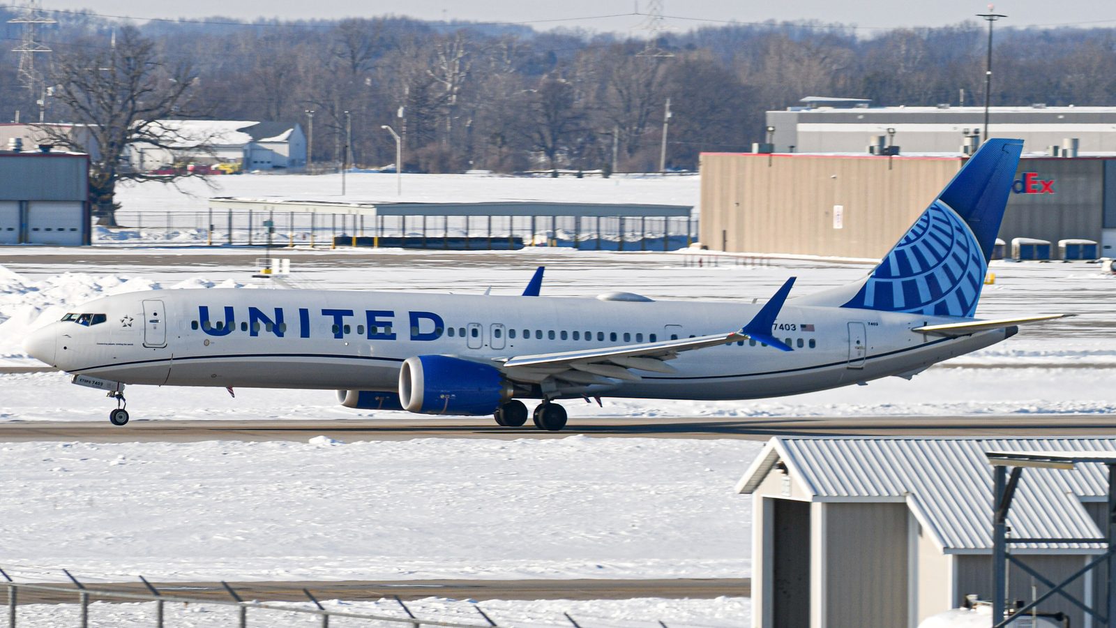 A United Airlines Boeing 737 MAX 9 taxiing on a snowy airfield