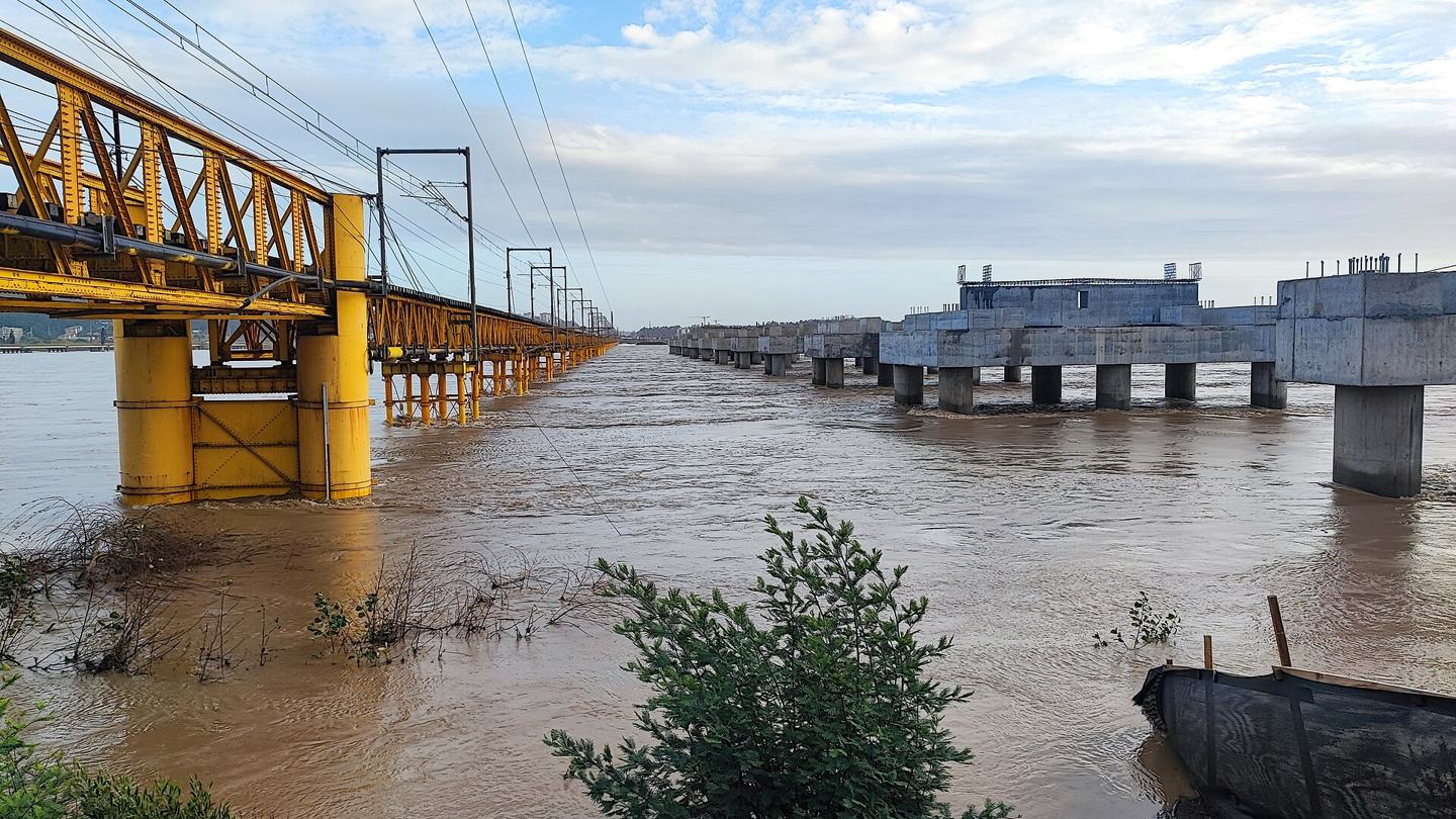 The swollen, muddy Biobío river flowing high around the pillars of railway bridges