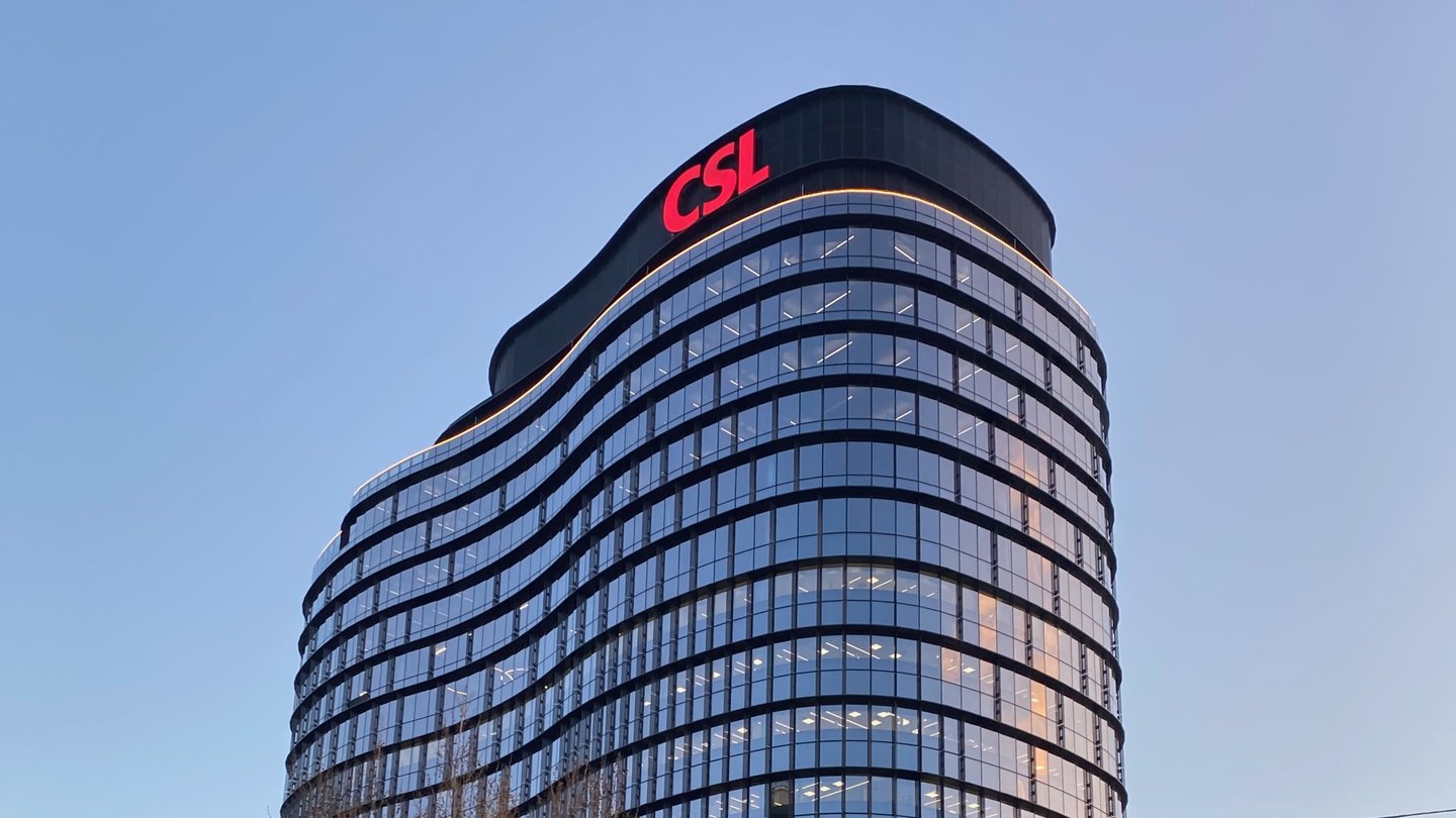 The curved glass CSL global headquarters tower in Parkville, Melbourne, with the red CSL logo at the top