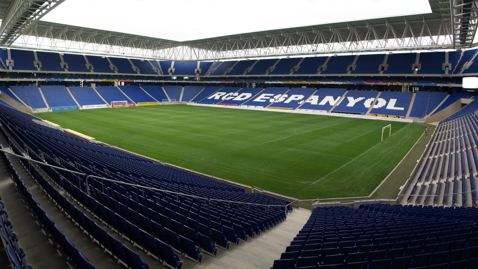 Panoramic view inside the RCDE Stadium in Cornellà, with blue seats and the pitch