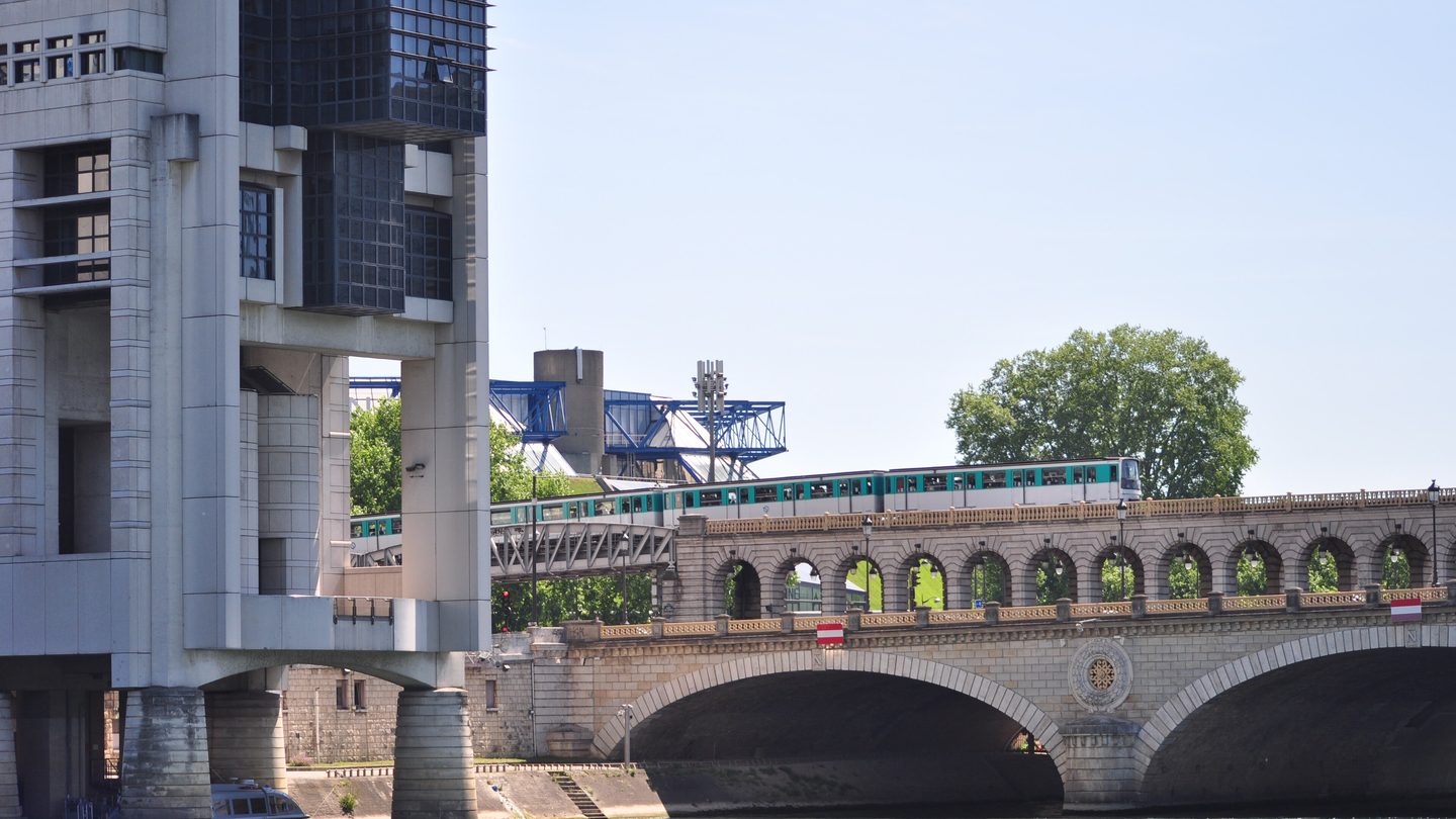 The Bercy building of France's economy and finance ministry beside the Pont de Bercy, with a metro train crossing the bridge