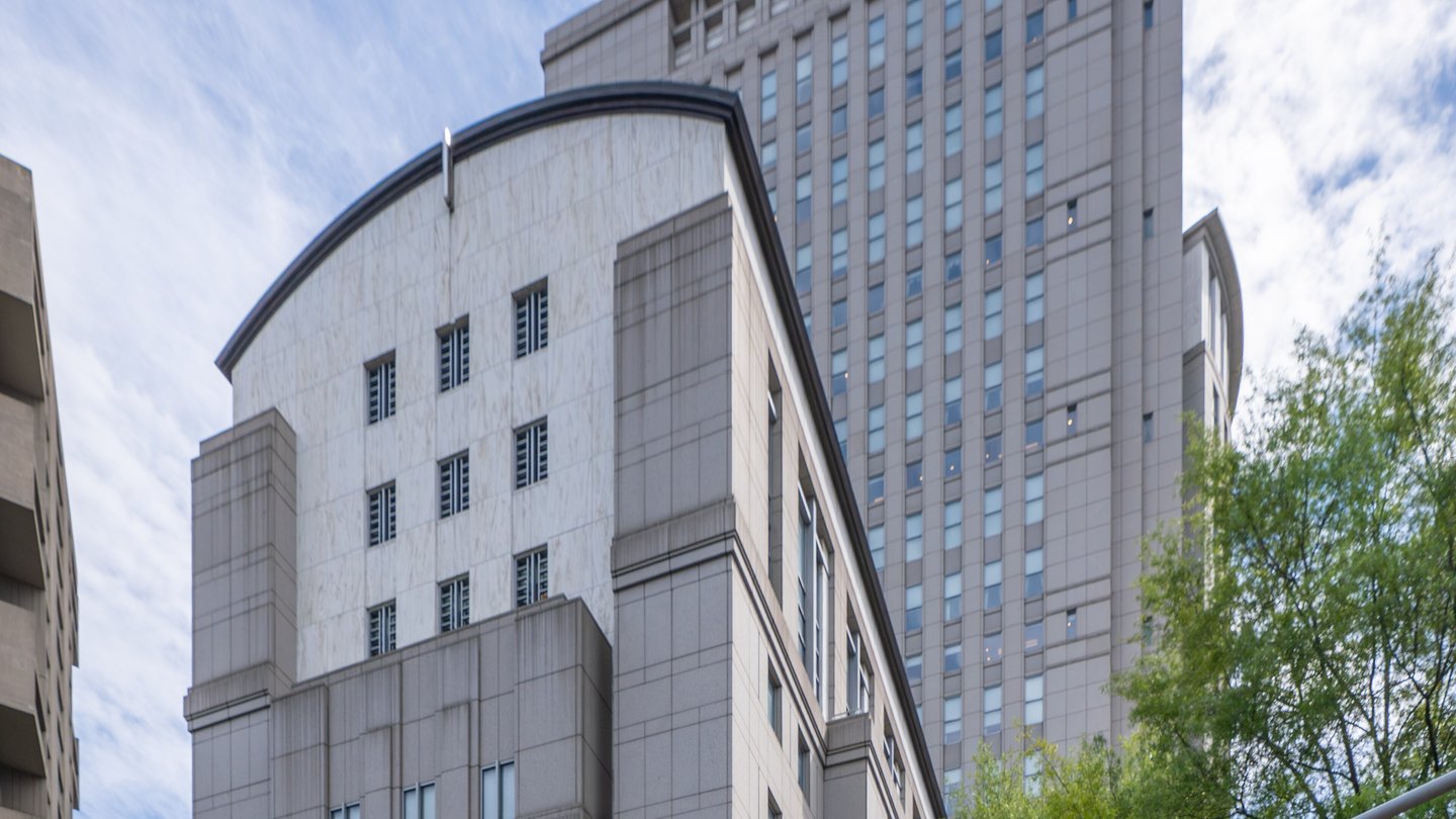 The Daniel Patrick Moynihan United States Courthouse, a tall grey stone tower with a curved lower building, in Lower Manhattan