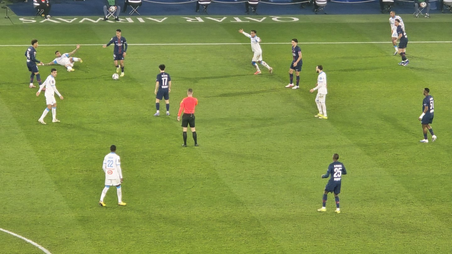 Marseille players in white and Paris Saint-Germain players in dark blue in action on the pitch at the Parc des Princes