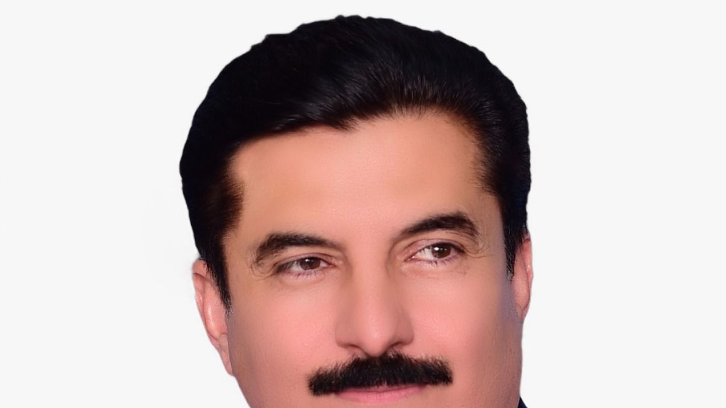 Official portrait of Khyber Pakhtunkhwa Governor Faisal Karim Kundi in a pinstriped suit with a Pakistani flag pin
