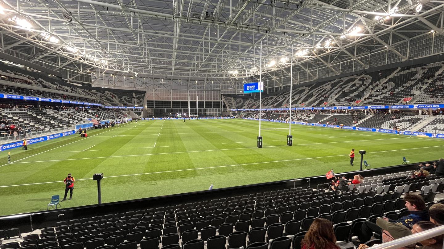Inside Te Kaha stadium in Christchurch under its clear roof, with the pitch, rugby posts and stands before a match