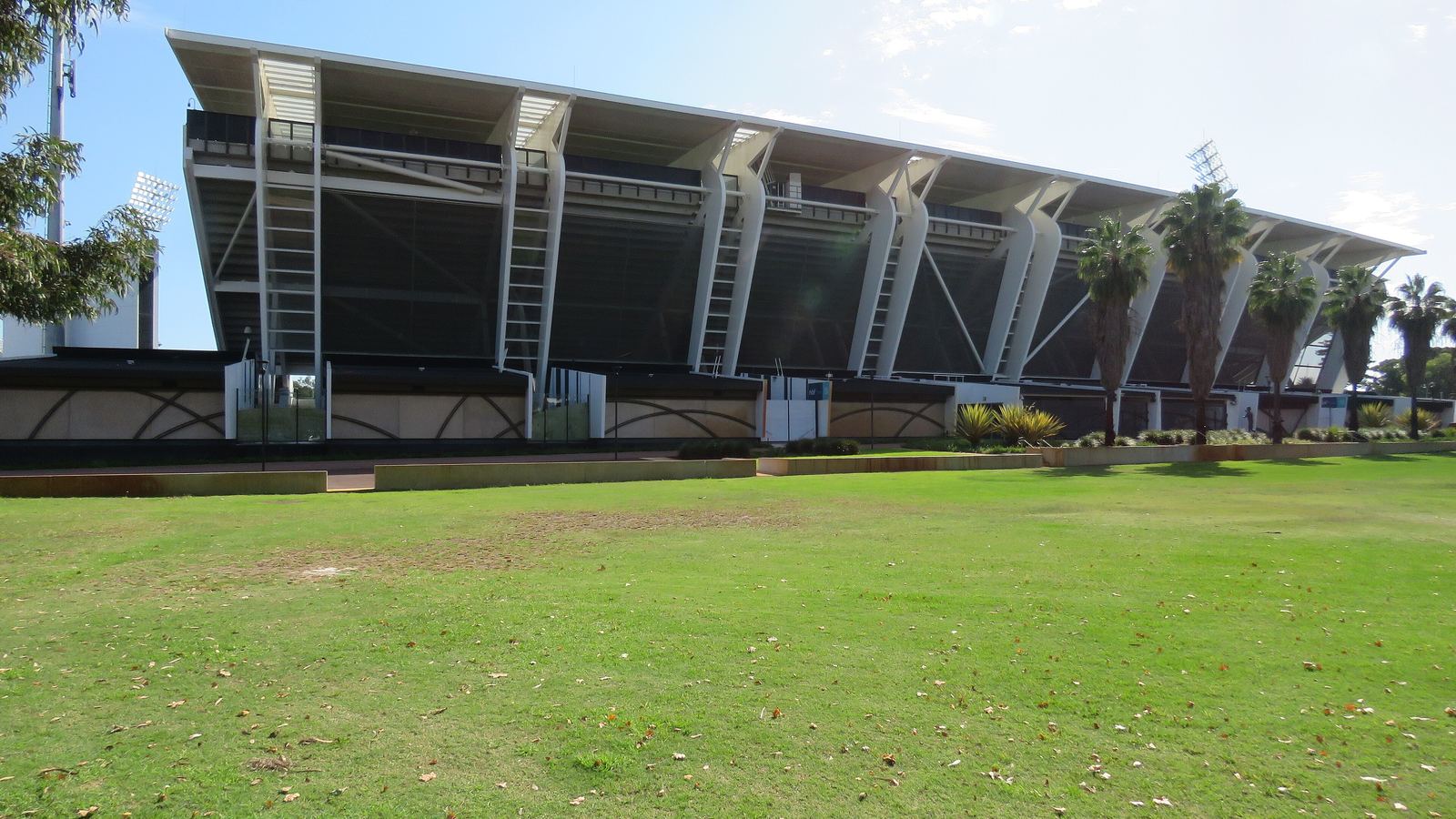 The grandstand of HBF Park, also called Perth Rectangular Stadium, seen from a grassed area under a blue sky