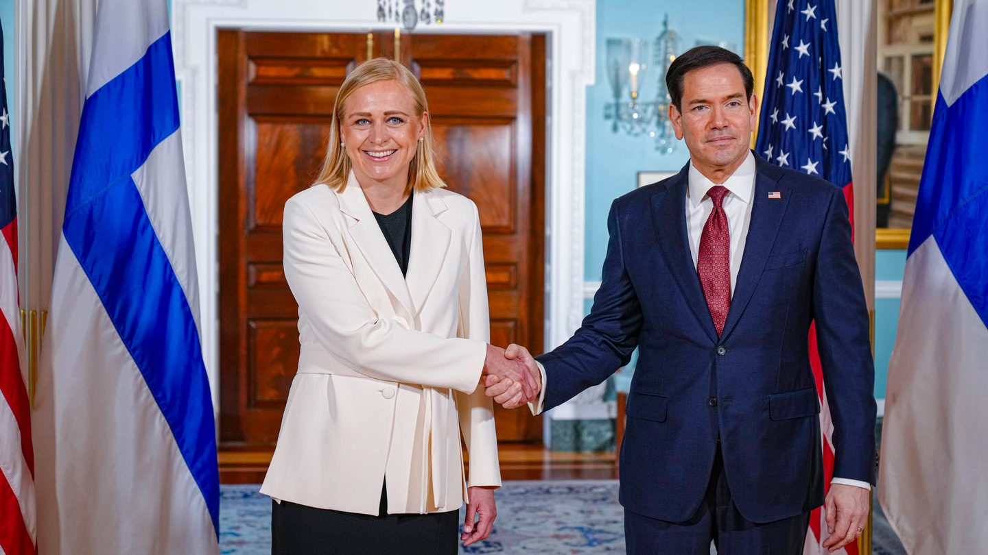US Secretary of State Marco Rubio shakes hands with Finnish Foreign Minister Elina Valtonen between US and Finnish flags at the State Department