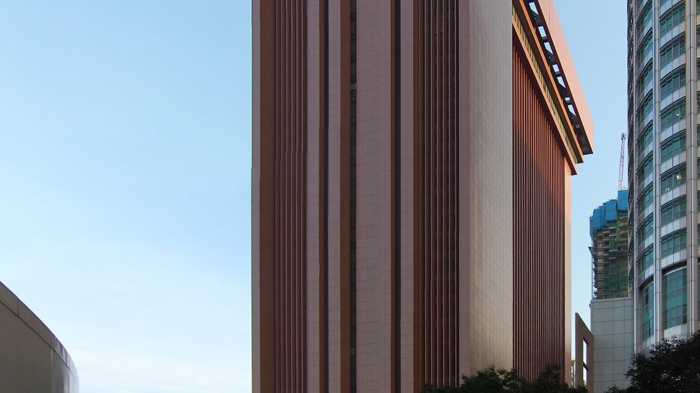 The tall, reddish-brown MAS Building on Shenton Way in Singapore against a blue sky