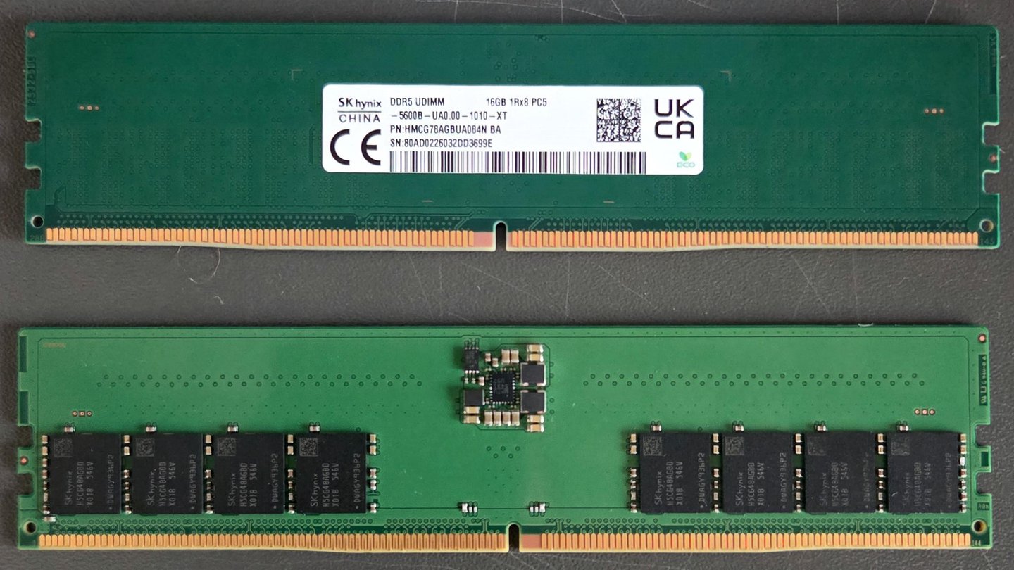 Two green SK hynix DDR5 desktop memory modules, front and back, on a grey surface