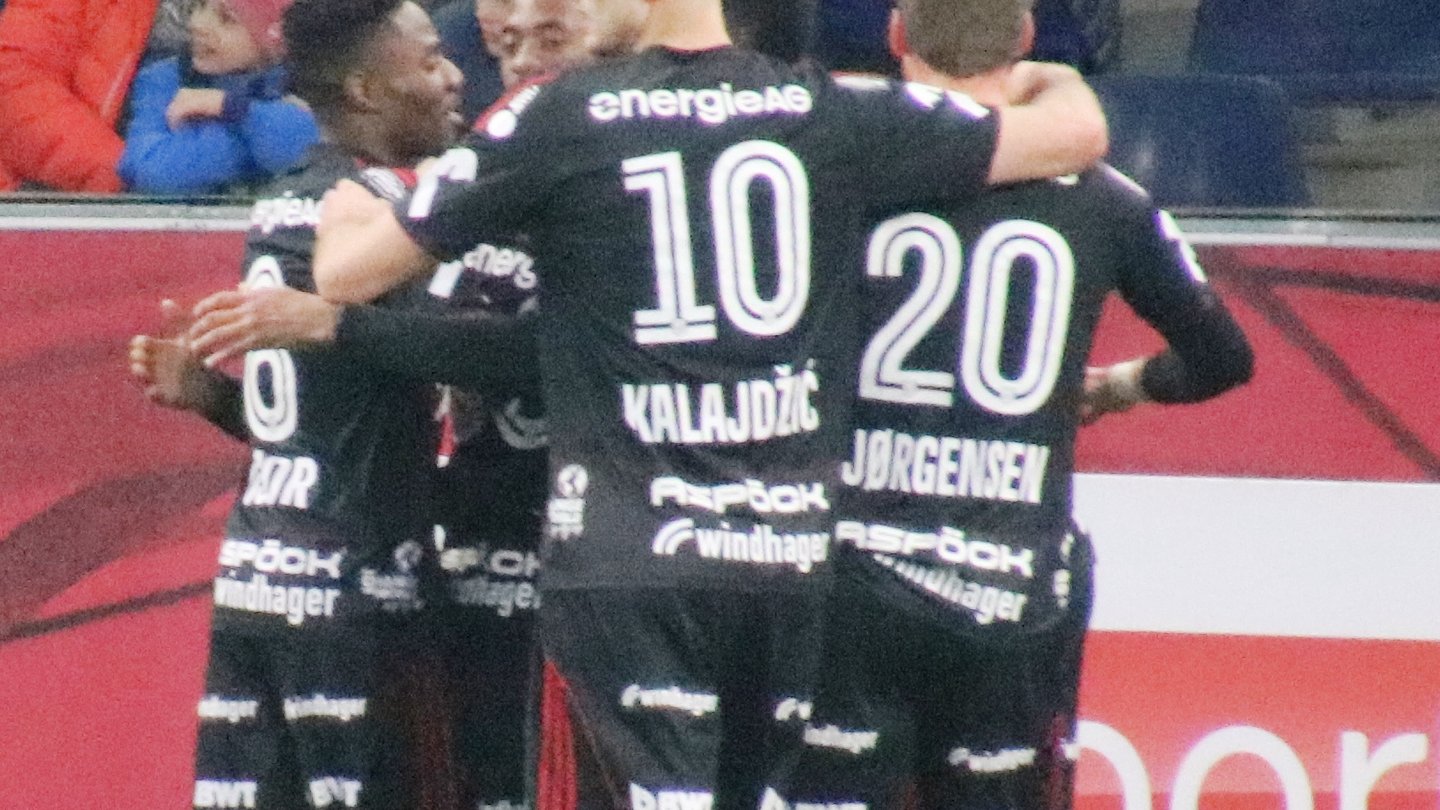 LASK players in black kits, including Saša Kalajdžić with the number 10, celebrating a goal