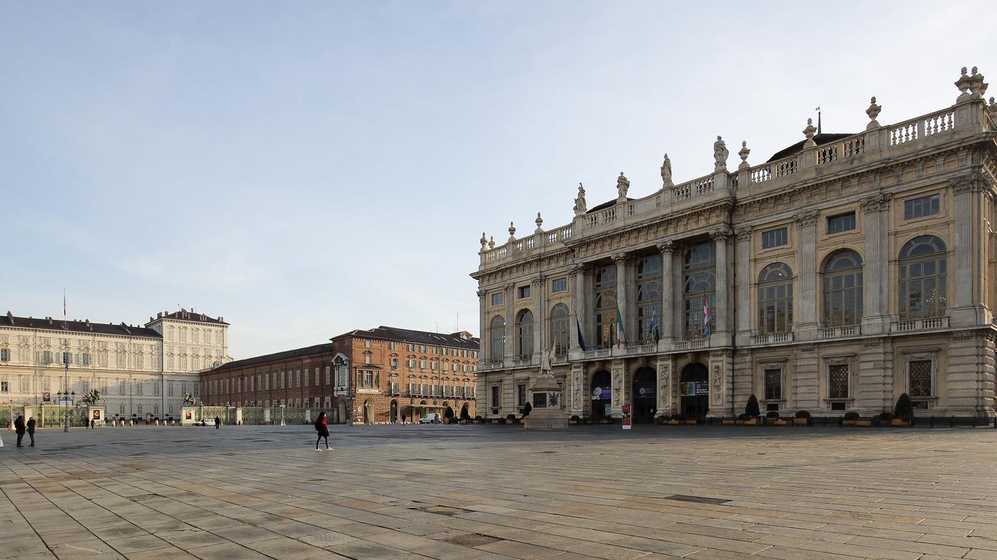 Piazza Castello in Turin, a wide stone-paved square with Palazzo Madama on the right and the Royal Palace in the distance