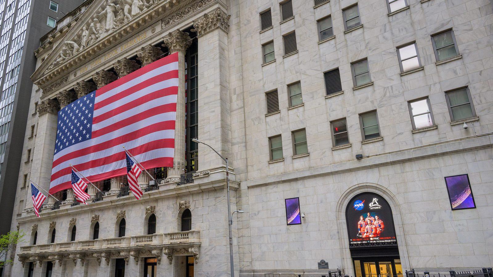 The New York Stock Exchange building on Broad Street with a large US flag hung across its columns